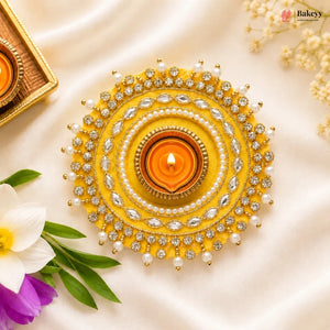 Decorative yellow and silver lamp with a lit candle on a light background, featuring Bakey brand.