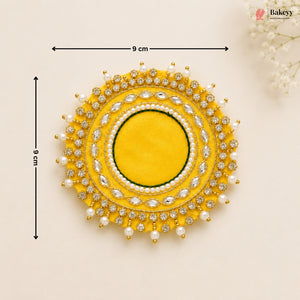 Decorative yellow circular piece with pearl and gemstone details, shown with measurements on a beige background.
