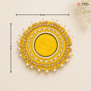Decorative yellow circular piece with pearl and gemstone details, shown with measurements on a beige background.