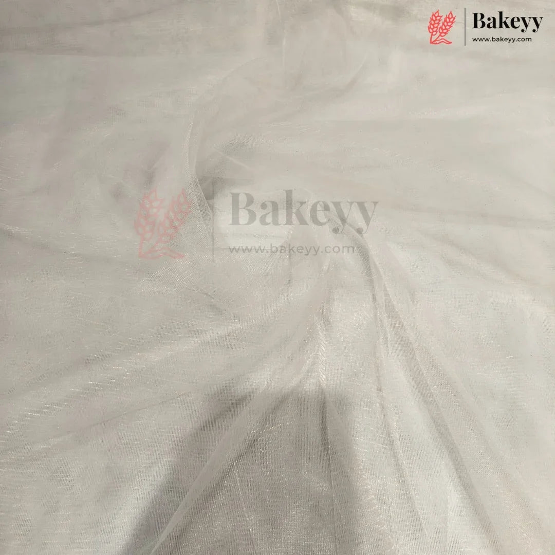 White tulle fabric draped to show its sheer, semi-transparent texture and fine mesh structure. The Bakeyy brand logo is visible in the top right corner.