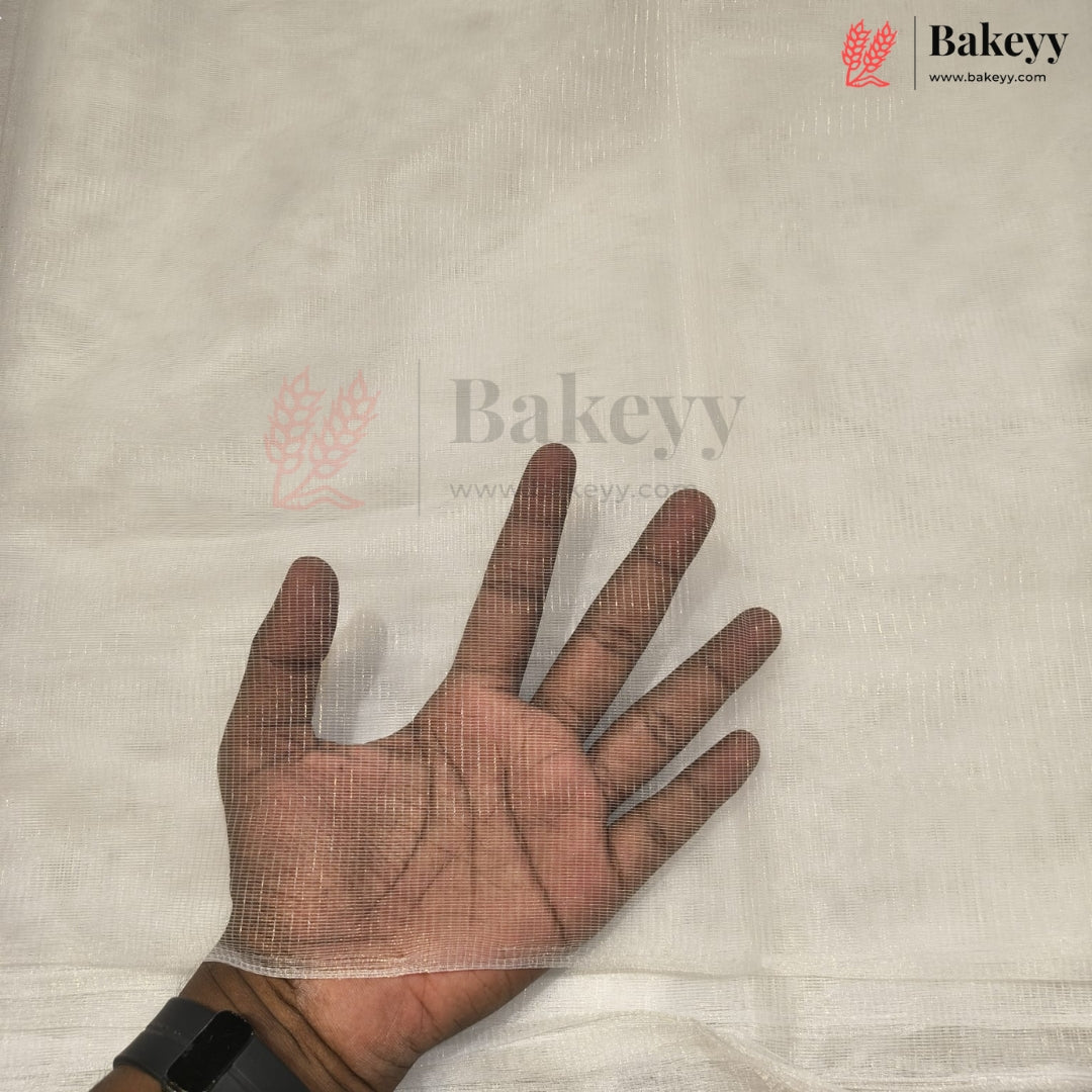A hand wearing a transparent mesh glove or protective cover over a light beige fabric surface, with Bakeyy branding visible on the image.