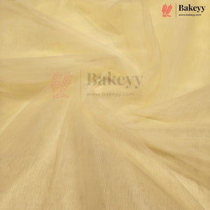 A close-up of draped pale yellow fabric with a soft, semi-sheer texture and visible weave, featuring a Bakeyy watermark logo in the center and top right corner.