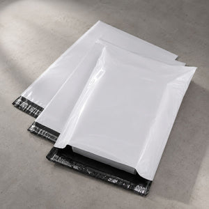 White mail envelopes with black sealing strips on a gray surface