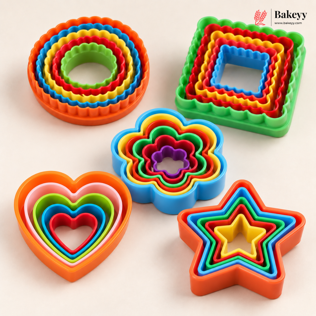 A set of colorful nested cookie cutters in multiple shapes including circles, squares, hearts, flowers, and stars, arranged on a light beige background with a Bakeyy logo in the top right corner.