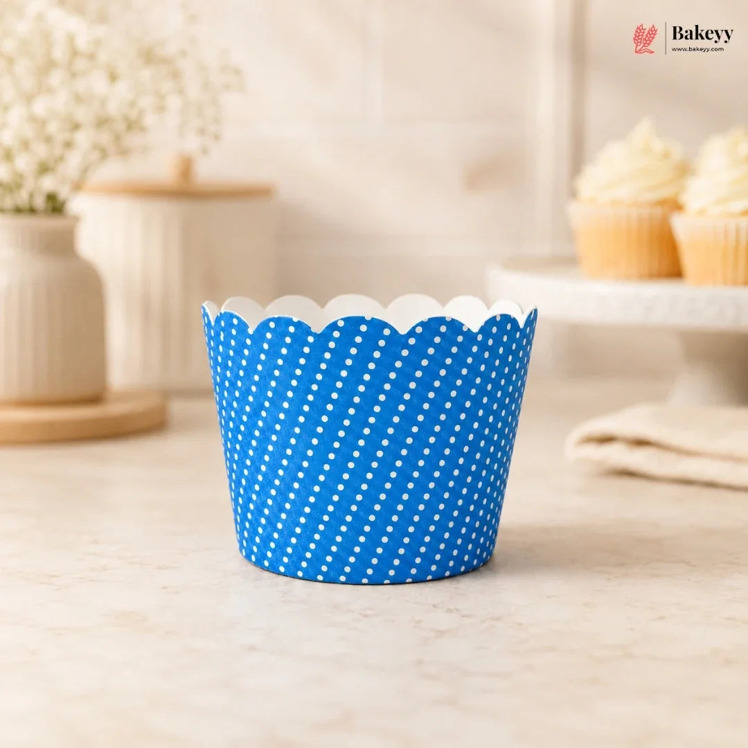 Blue polka dot cupcake liner on a light wooden surface with a blurred background