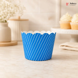Blue polka dot cupcake liner on a light wooden surface with a blurred background