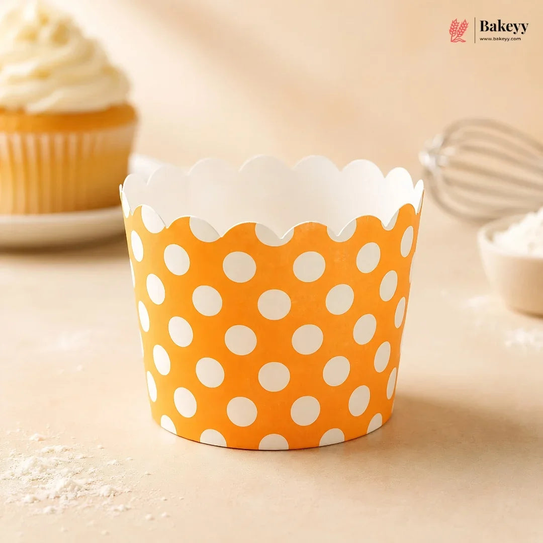 Orange cupcake liner with white polka dots on a light background, featuring the Bakey brand.
