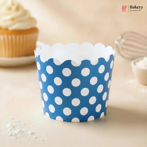 Blue polka dot cupcake wrapper on a light surface with a blurred background