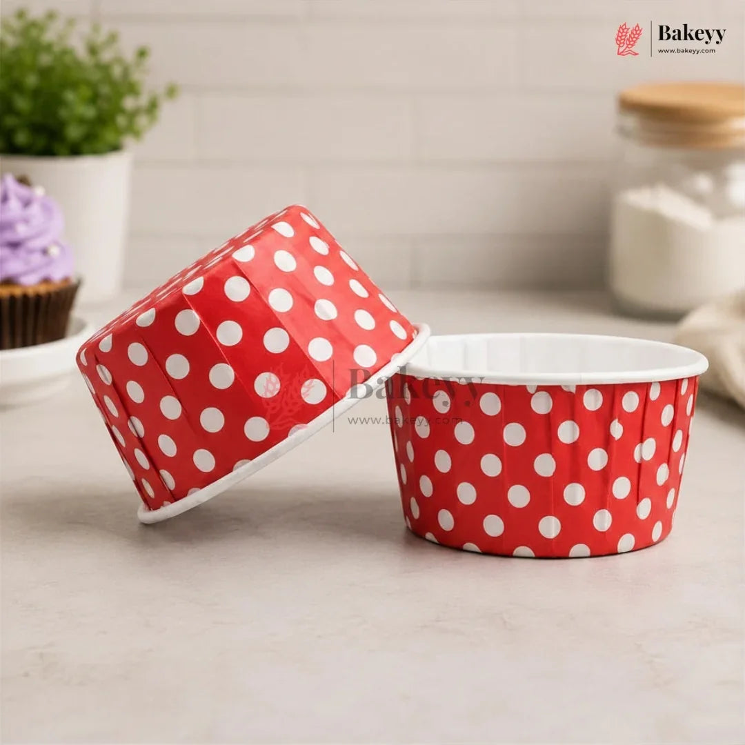 Red polka dot baking cups on a light surface with a blurred background