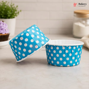 Blue paper cupcake liners with white polka dots on a kitchen counter.