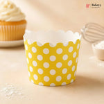 Yellow cupcake liner with white polka dots on a beige surface, with 'Bakey' branding.