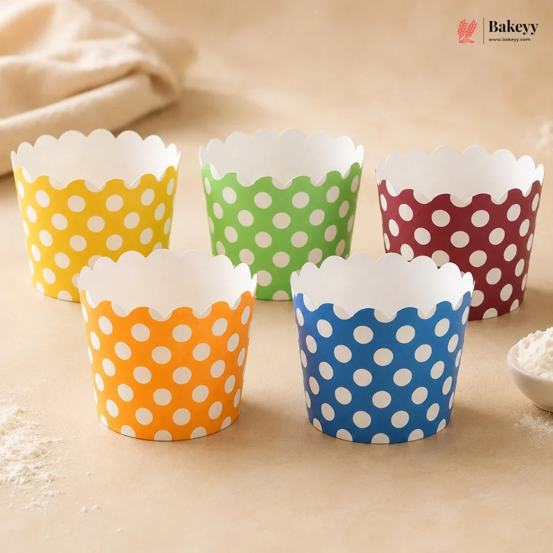 Five colorful polka dot cupcake liners on a beige surface with 'Bakey' branding.