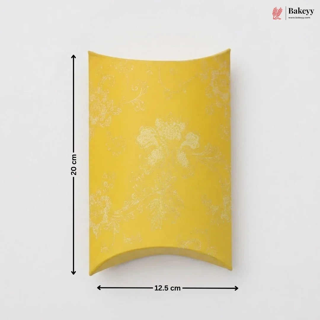 Yellow pillow-shaped packaging with floral patterns and measurements on a white background