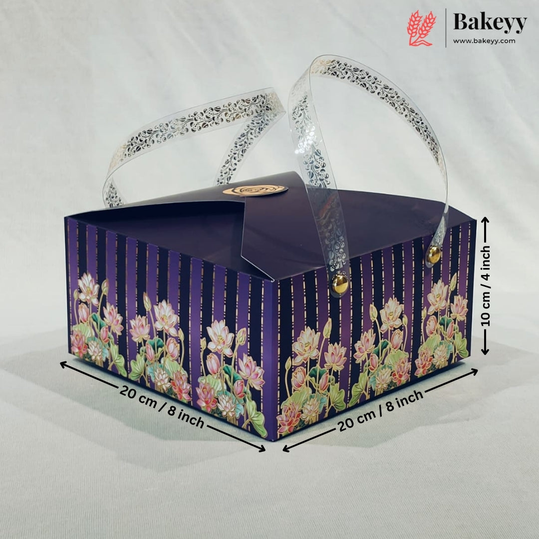 A rectangular bakery gift box with a dark purple lid and floral-patterned sides, shown on a light fabric background with dimension arrows and text indicating 20 cm by 20 cm and 10 cm height. A Bakeyy logo appears in the top right corner.