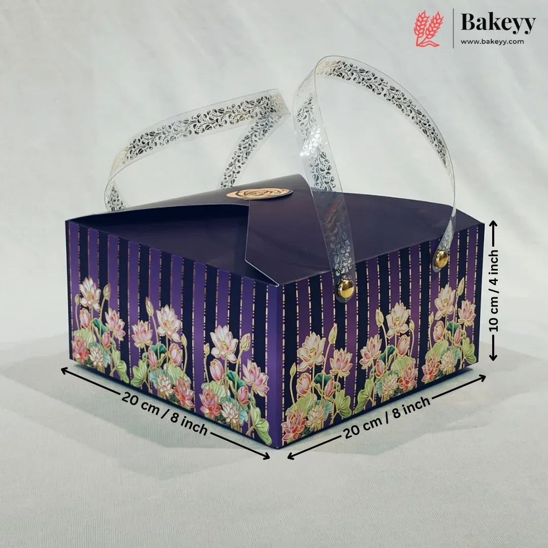 A rectangular bakery gift box with a dark purple lid and floral-patterned sides, shown on a light fabric background with dimension arrows and text indicating 20 cm by 20 cm and 10 cm height. A Bakeyy logo appears in the top right corner.
