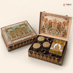 An ornate traditional Indian gift box set shown closed and open on a light beige background. The set includes a large decorated box with a detailed architectural illustration on the lid, three small round gold-lidded jars, and a square wrapped item.