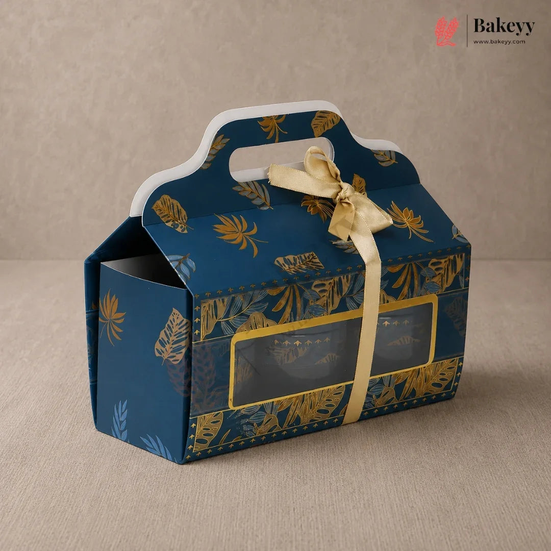 Blue gift box with gold leaf pattern and ribbon on a beige background, featuring the brand 'Bakeyy'.