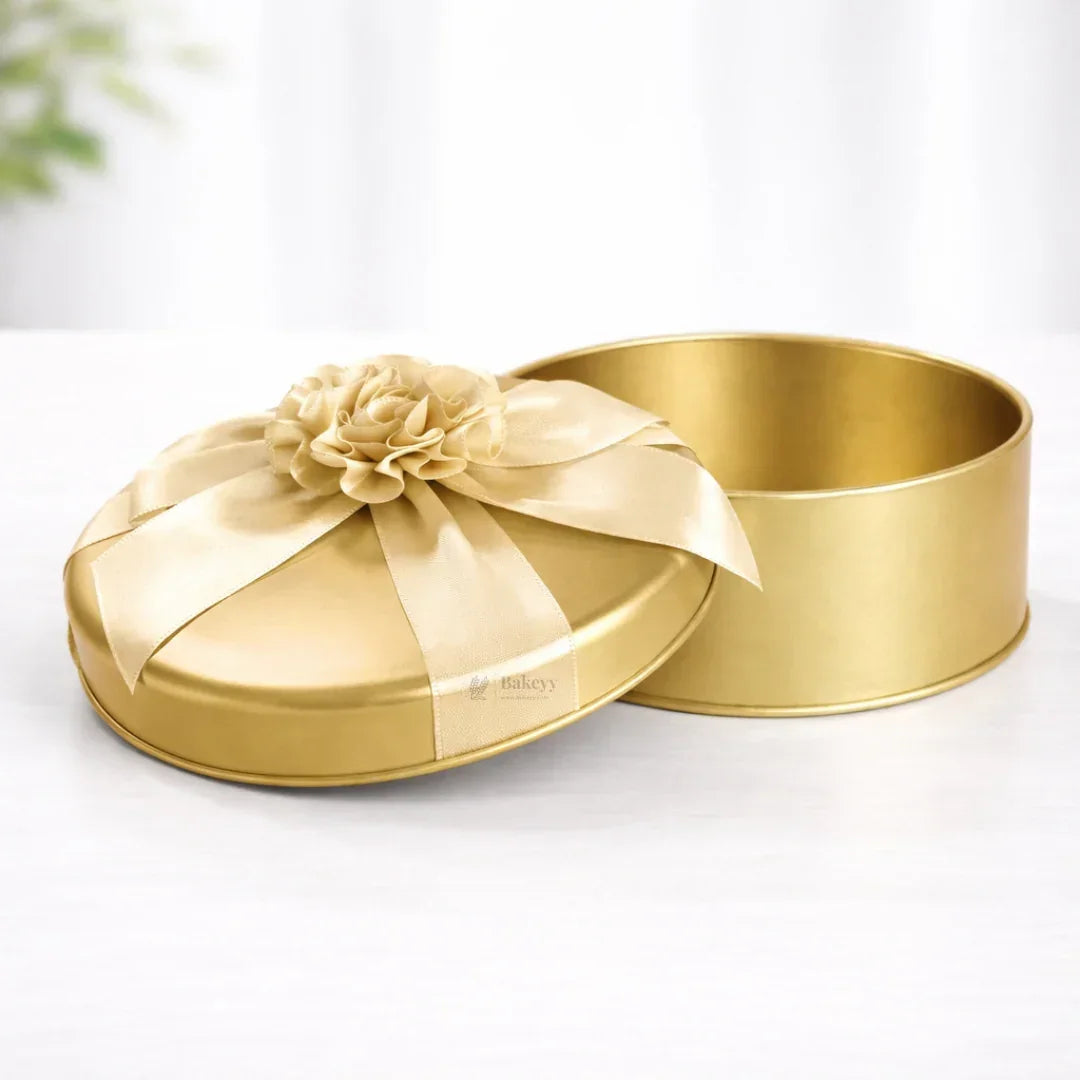 Premium round gold tin box with ribbon and flower, ideal for gift packaging from Bakeyy