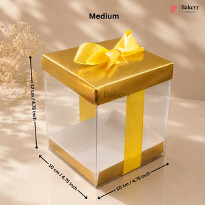 Gold gift box with clear sides and a yellow ribbon, showing dimensions and the brand 'Bakeyy'.