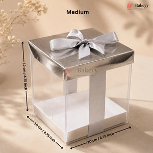 Silver gift box with a bow and dimensions on a beige background, featuring the Bakeyy brand.