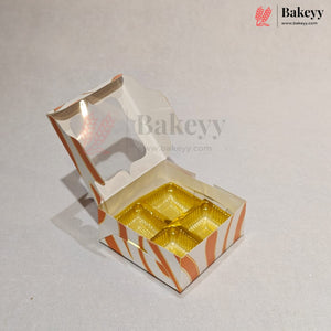 An open custom bakery box with a hinged lid, featuring orange and white wavy stripes and a clear window, containing four gold-colored round cupcake liners, set against a light gray background.