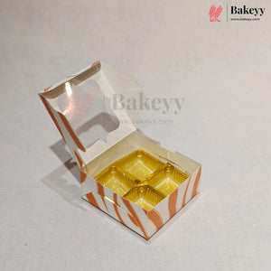 An open custom bakery box with a hinged lid, featuring orange and white wavy stripes and a clear window, containing four gold-colored round cupcake liners, set against a light gray background.