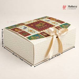 A rectangular bakery gift box with a cream-colored textured exterior, a decorative multicolor patchwork-patterned top, and a cream satin ribbon tied in a bow. Black dimension arrows and text indicate measurements of 18 cm / 7 inch, 23 cm / 9 inch, and 7.