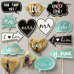 Collection of wedding-themed photo booth props on sticks with text and heart designs.