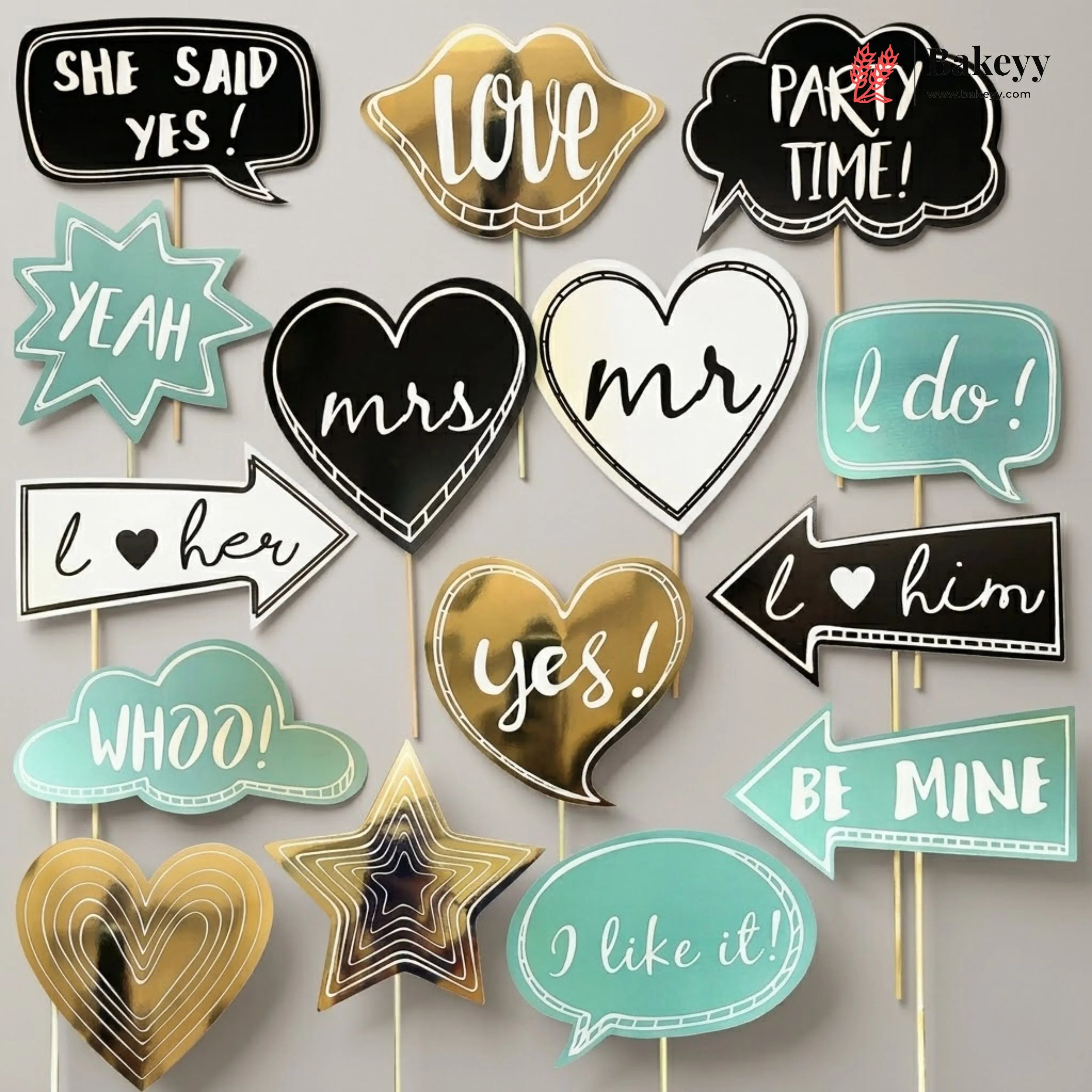Collection of wedding-themed photo booth props on sticks with text and heart designs.