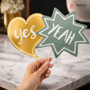 Hand holding 'Yes' and 'Yeah' signs on sticks with a blurred background