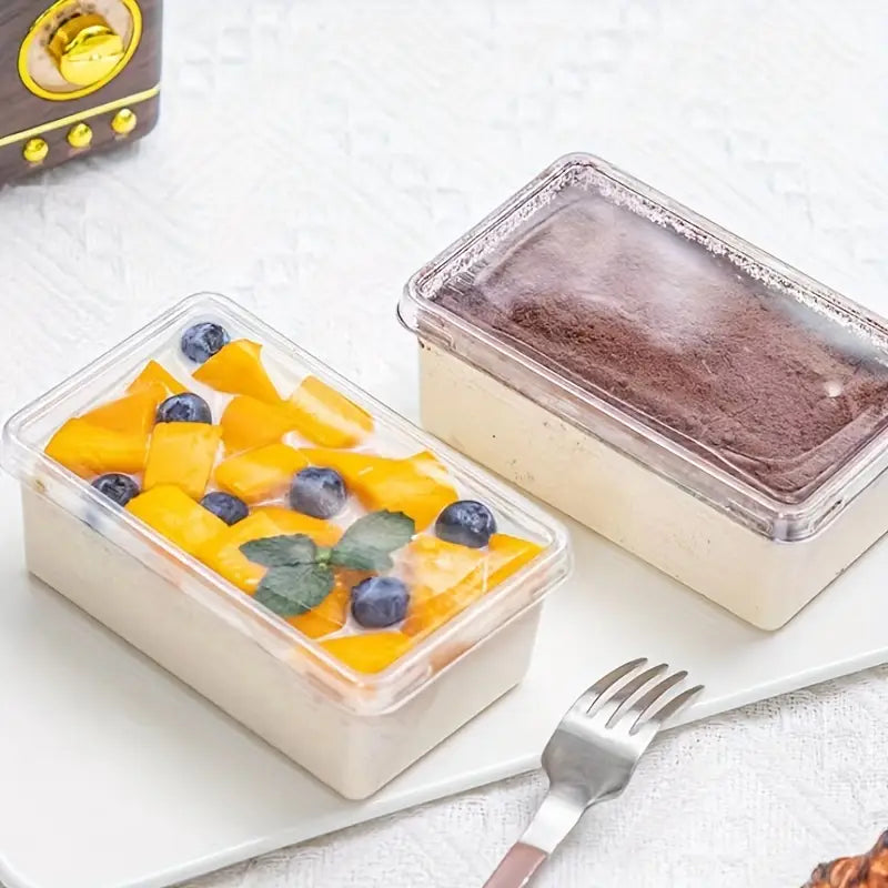 Two dessert containers with fruit and chocolate on a white surface.