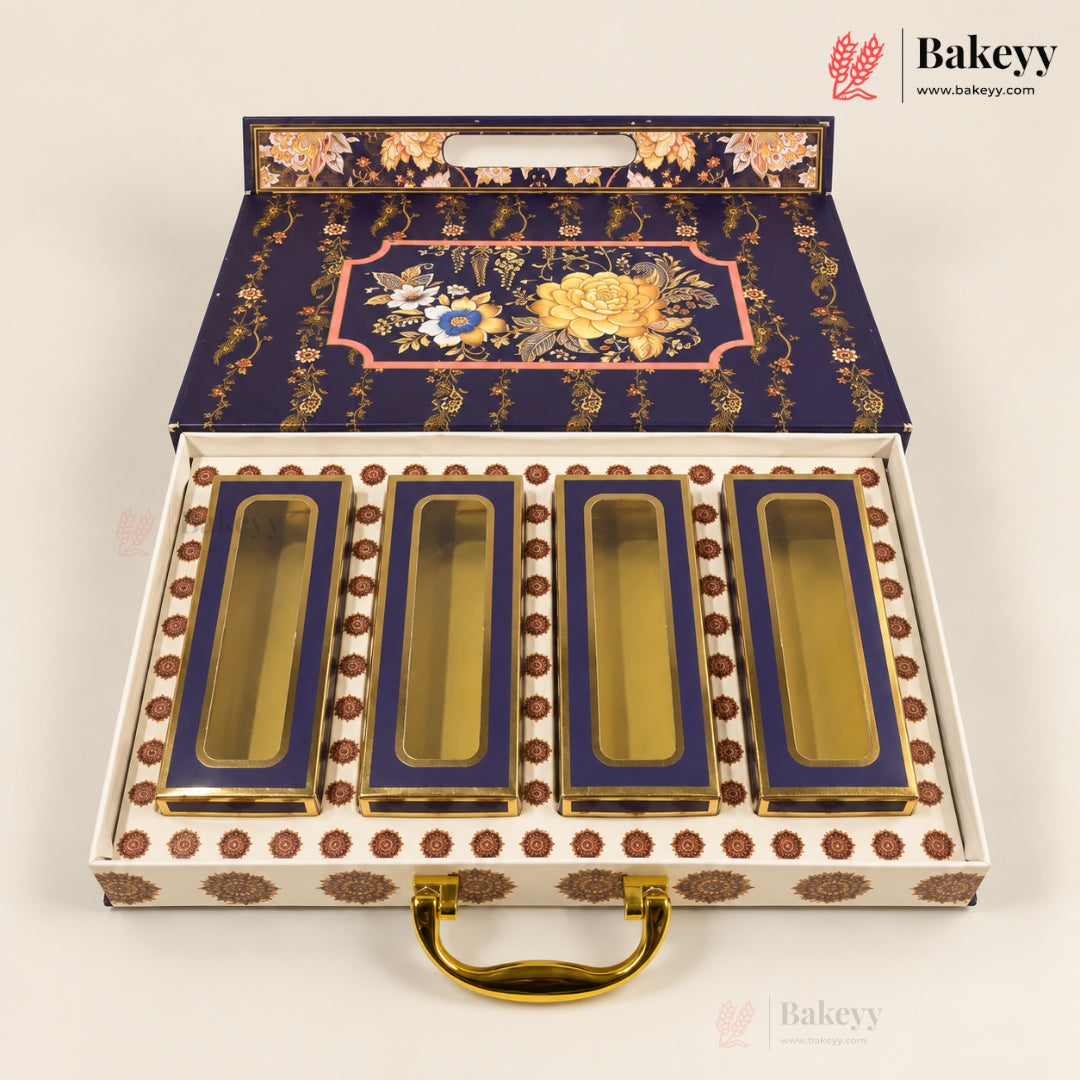 An ornate open gift box containing four rectangular glass jars with gold-toned lids and deep blue interiors. The box lid and base are decorated with gold floral motifs and brown circular accents, and the set is photographed on a clean white background.