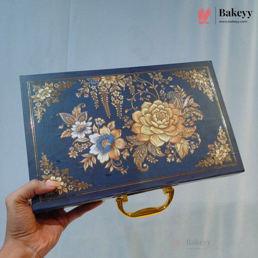 A rectangular decorative box with a dark blue background and ornate gold floral and botanical illustrations, held by a hand. The box has a gold handle and a Bakeey watermark/logo on the top right.