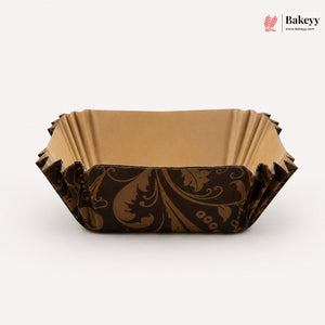 Decorative brown paper cake board with intricate patterns on a white background, featuring the Bakeyy brand.