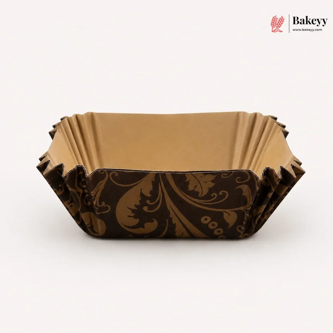 Decorative brown paper cake board with intricate patterns on a white background, featuring the Bakeyy brand.