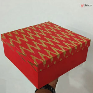 Red box with gold patterns held by a hand on a white background