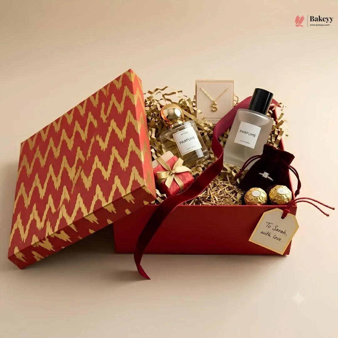 Gift box with perfume, chocolates, and jewelry on a beige background