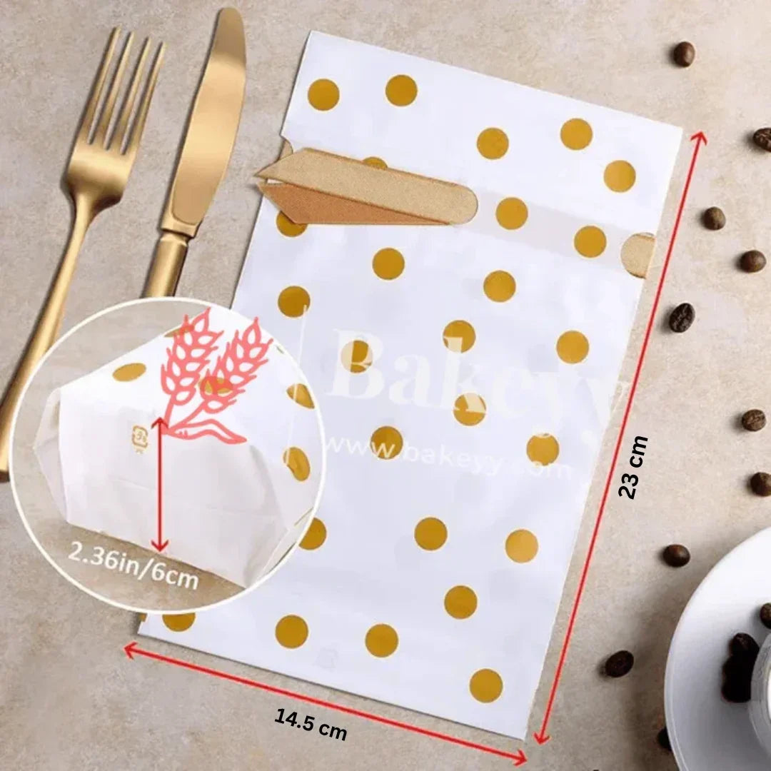 White paper napkin with gold polka dots, cut into a leaf shape, on a beige surface with coffee beans and cutlery.