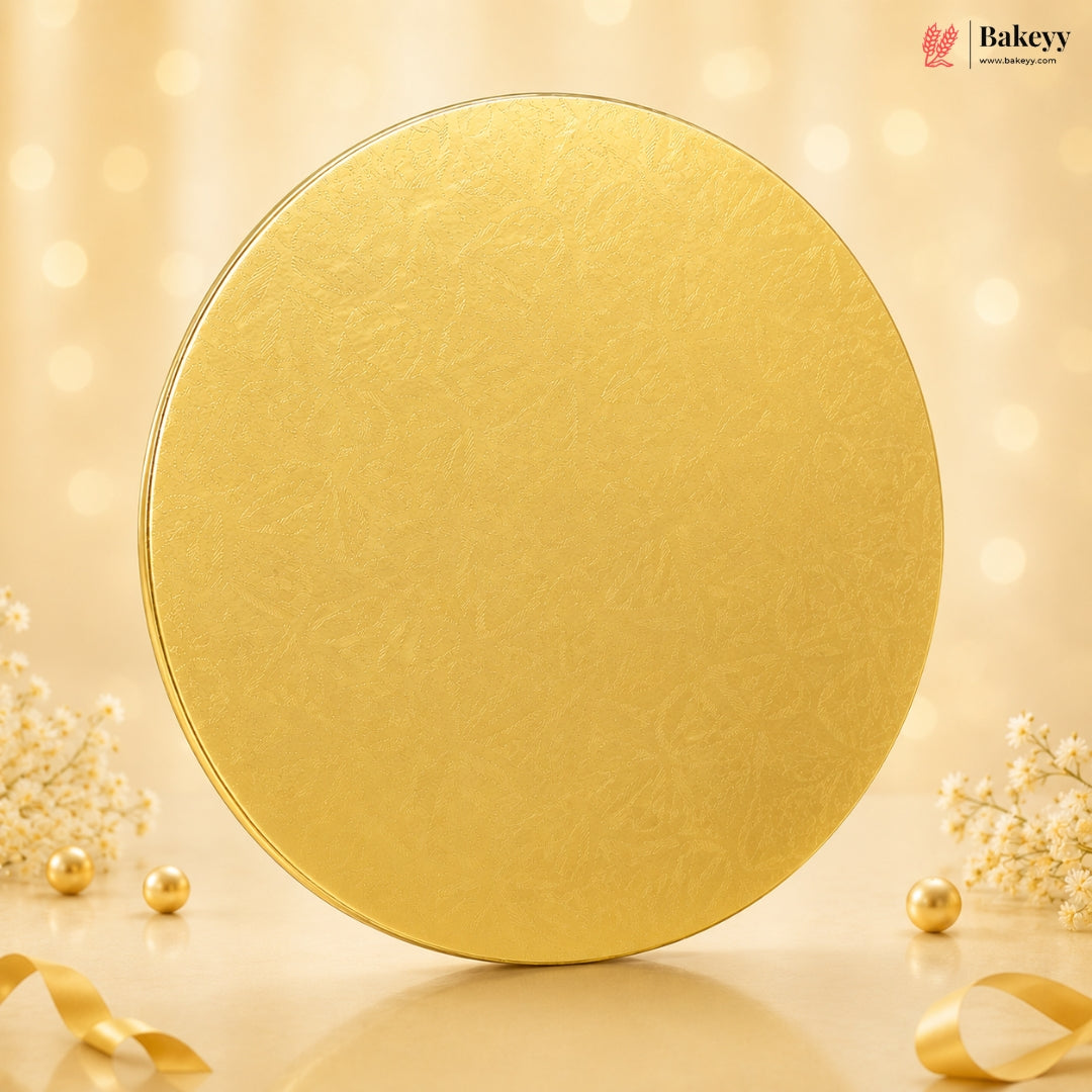 Gold round cake board with decorative elements on a beige background