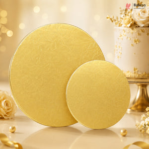 Two gold cake boards on a decorative background with flowers and ribbons.