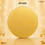 A round gold-colored tin with a subtle embossed floral pattern, standing upright on a reflective surface. The background is a warm, soft beige with bokeh lights and decorative pearl-like flowers.