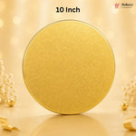 A round gold-colored tin with a subtle embossed floral pattern, standing upright on a reflective surface. The background is a warm, soft beige with bokeh lights and decorative pearl-like flowers.