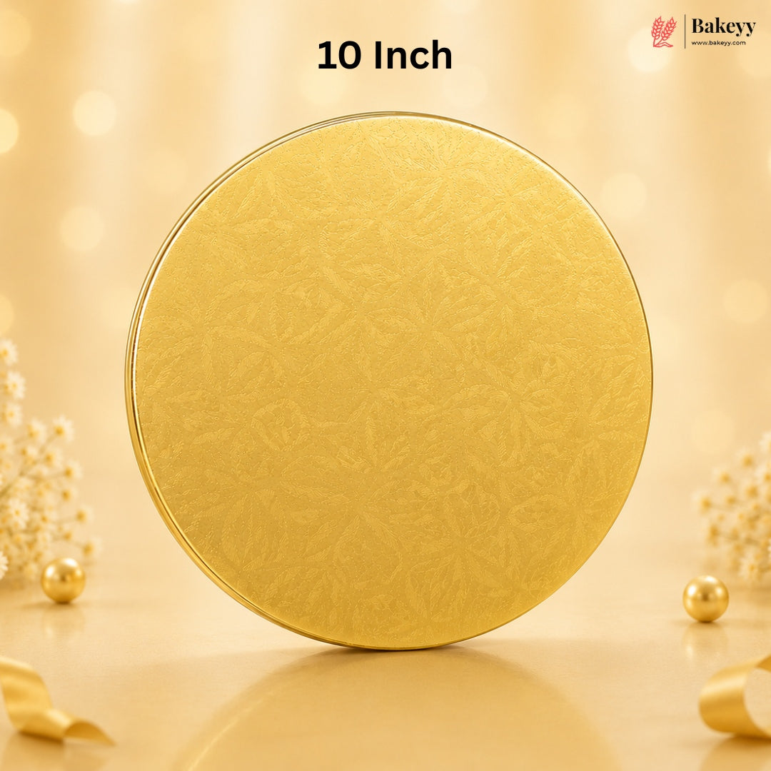 A round gold-colored tin with a subtle embossed floral pattern, standing upright on a reflective surface. The background is a warm, soft beige with bokeh lights and decorative pearl-like flowers.