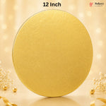 A round gold cake topper or decorative lid with a subtle embossed pattern, shown on a warm beige background with bokeh lights and small decorative flowers and pearls. Text at the top reads '12 Inch' and a Bakeyy logo appears in the upper right.