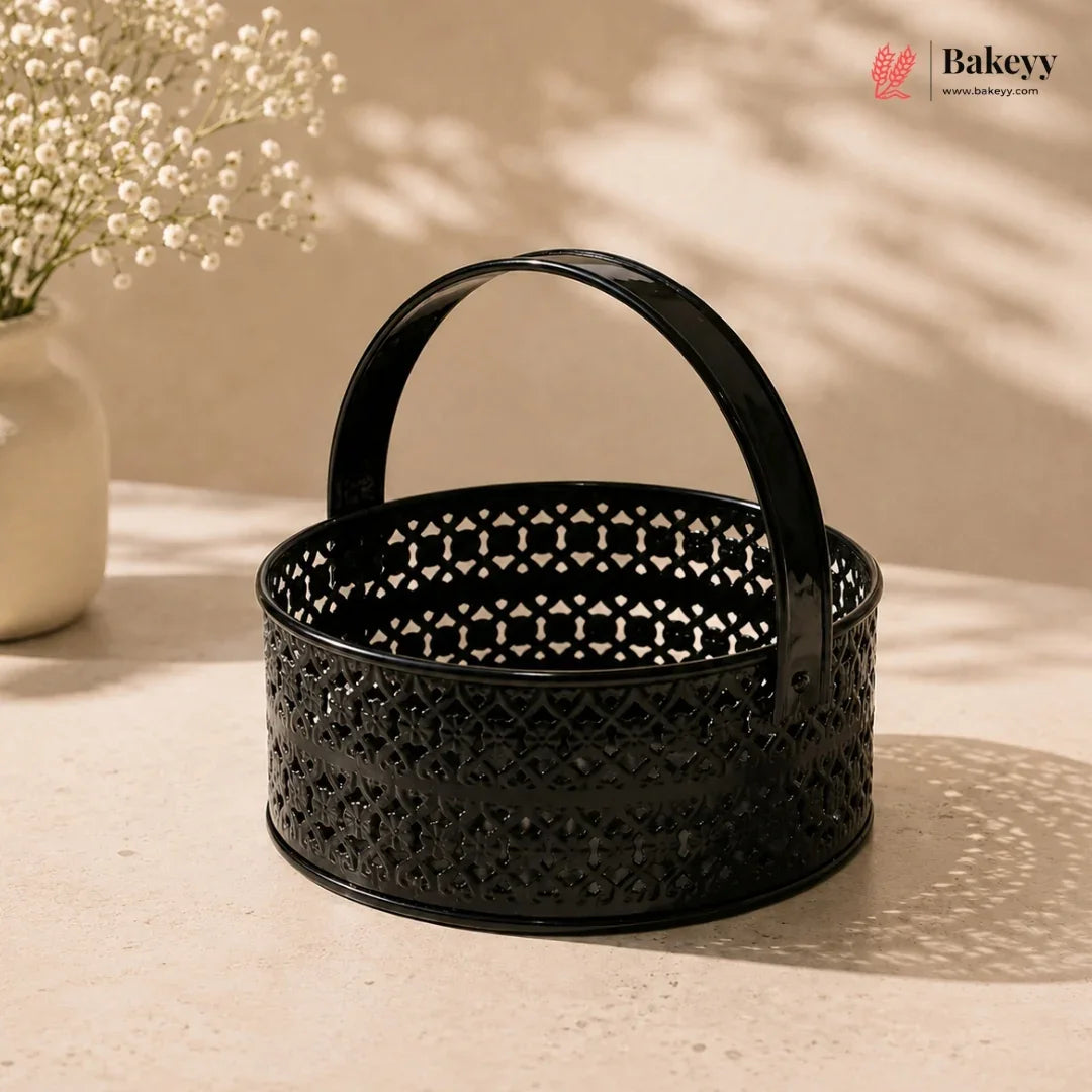 Black decorative basket with intricate patterns on a beige surface, featuring the Bakeyv brand.