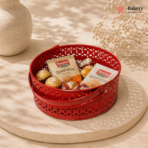 Red decorative basket with snacks and cookies on a beige surface, featuring the Bakeyy brand.
