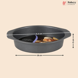 A dark gray round baking pan with built-in handles, shown on a beige background with overlaid dimension lines indicating 18 cm width, 21.5 cm diameter, and 5 cm height.