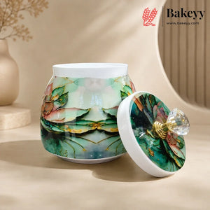 A ceramic jar with a matching lid, decorated with a green and teal floral pattern and gold accents, set against a warm beige background. The brand logo 'Bakeyy' is visible in the top right corner.