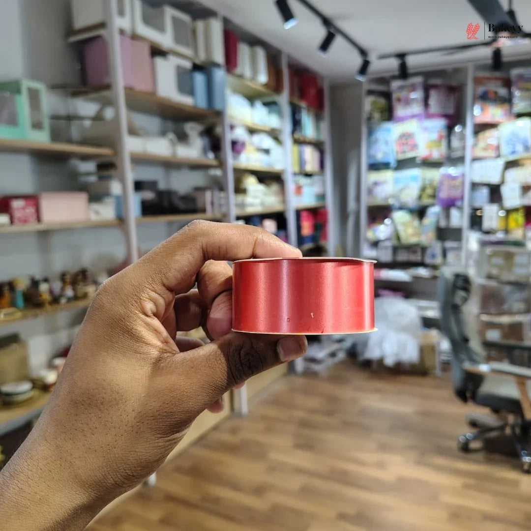 Hand holding a red cylindrical object with shelves and products in the background