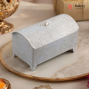 Silver glittery box on a decorative plate with 'Bakeyy' branding.